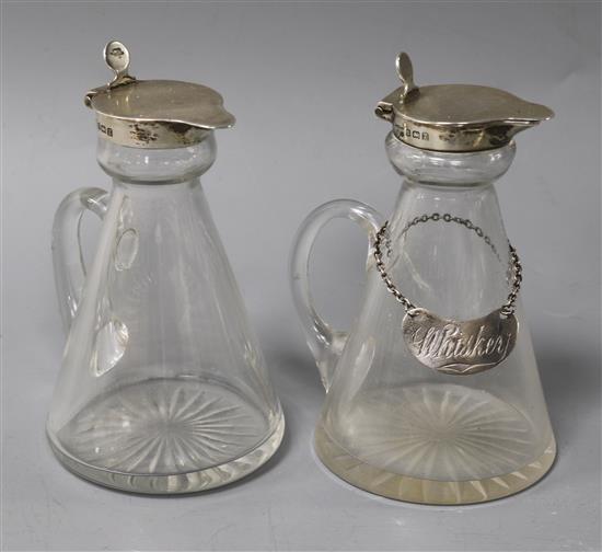 Two George V silver mounted glass whisky tot jugs by Mappin & Webb, Birmingham, 1924, one with a silver label, 11.1cm.